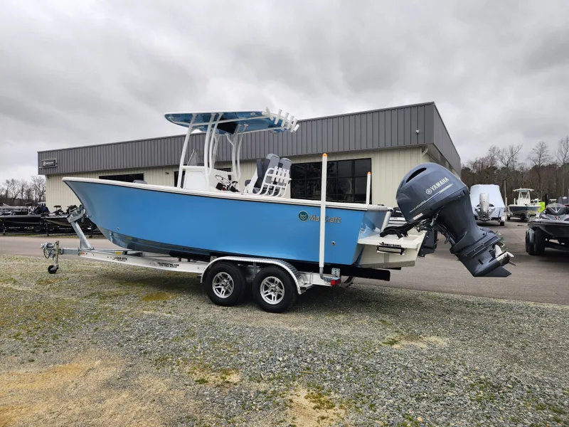 Slide: The Image of 2025 May-Craft 245 Offshore CC boat on trailer, blue hull, Yamaha outboard, parked outside dealership. - 5