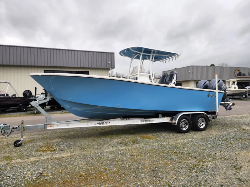 Slide: The Image of 2025 May-Craft 245 Offshore CC boat on trailer, blue hull, parked outdoors. - 7