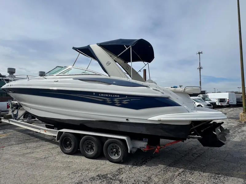 Slide: The Image of 2008 Crownline 315 SCR boat on trailer, blue and white design, parked outdoors. - 1