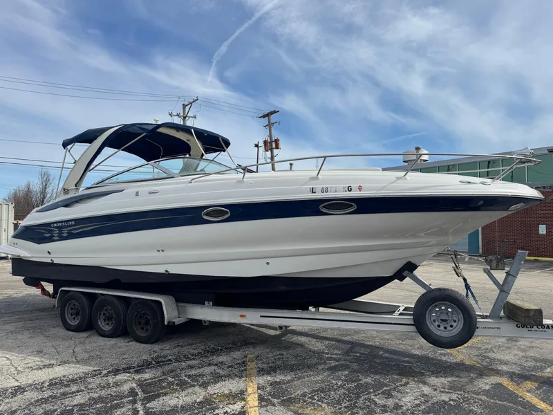 Slide: The Image of 2008 Crownline 315 SCR boat on trailer, parked outdoors under a clear sky. - 4