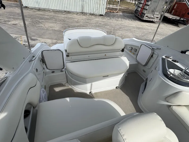 Slide: The Image of 2008 Crownline 315 SCR boat interior with white seating and compact kitchenette. - 8