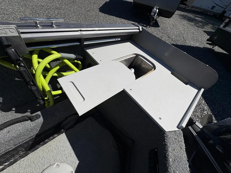 Slide: The Image of 2017 Lund 1800 Sport Angler boat interior with storage compartment and yellow hose. - 10
