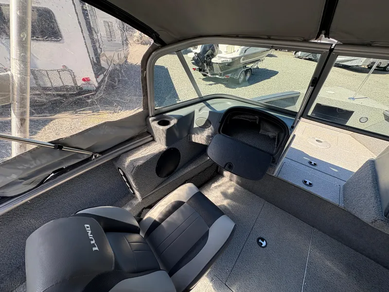 Slide: The Image of Interior of a 2017 Lund 1800 Sport Angler boat with seating and storage compartments. - 18