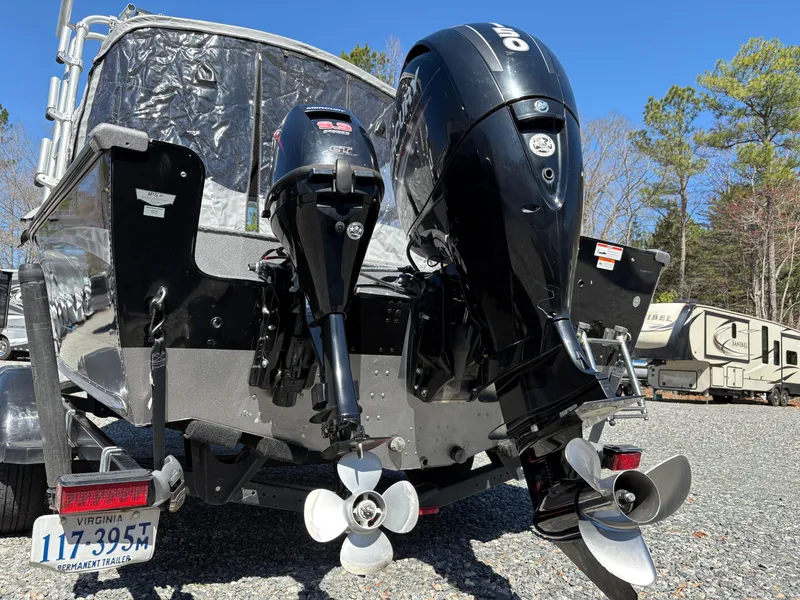 Slide: The Image of 2017 Lund 1800 Sport Angler boat with dual outboard motors, parked on gravel. - 7