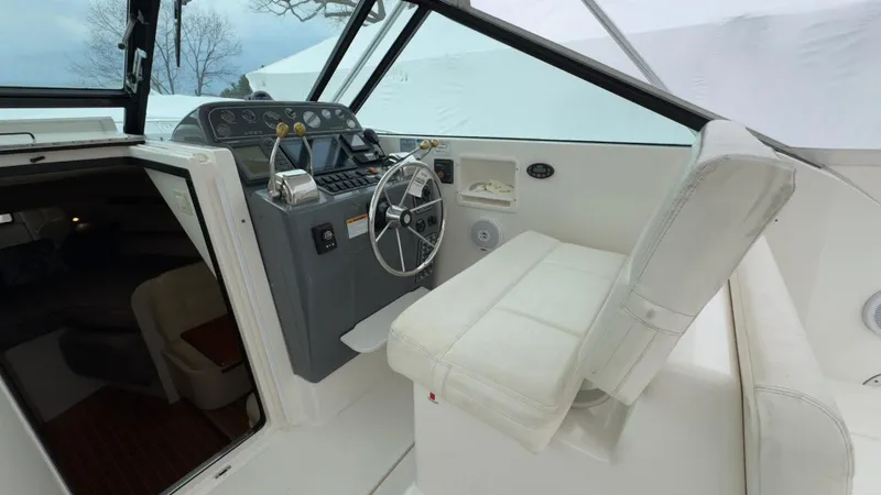Slide: The Image of 2005 Tiara Yachts 2900 Open helm with white seating and control panel. - 16