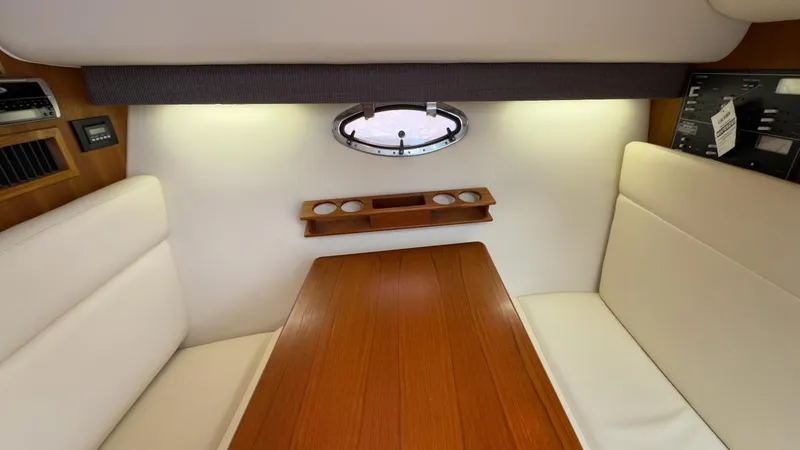 Slide: The Image of 2005 Tiara Yachts 2900 Open cabin interior with wood table and cushioned seating. - 26
