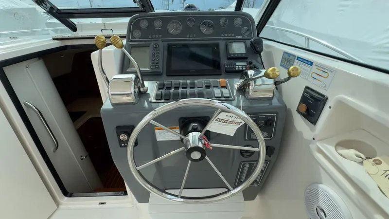 Slide: The Image of 2005 Tiara Yachts 2900 Open helm with steering wheel and control panel. - 19