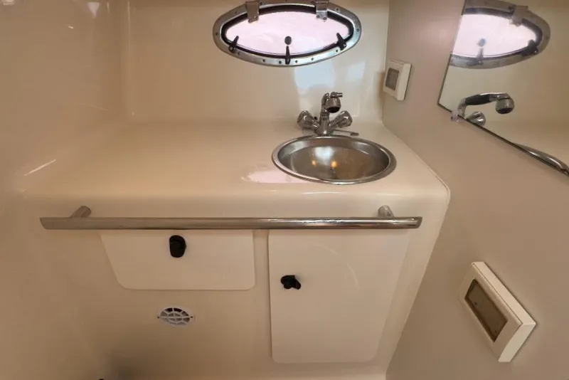 Slide: The Image of 2005 Tiara Yachts 2900 Open bathroom with sink, mirror, and porthole window. - 44
