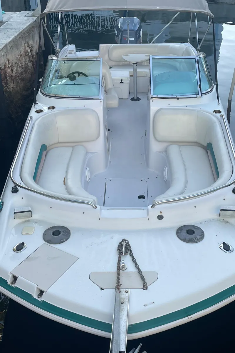 Slide: The Image of 2000 Hurricane SunDeck 237 OB boat docked, featuring spacious seating and open deck design. - 13
