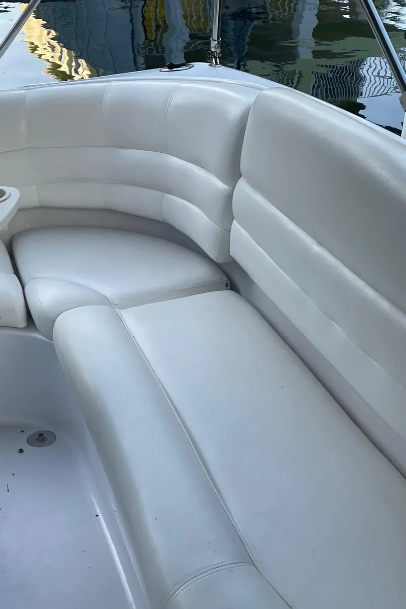 Slide: The Image of 2000 Hurricane SunDeck 237 OB boat with white cushioned seating. - 14