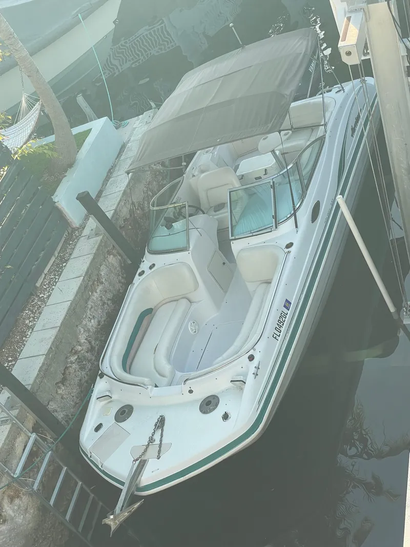 Slide: The Image of 2000 Hurricane SunDeck 237 OB boat docked with canopy, white exterior. - 6