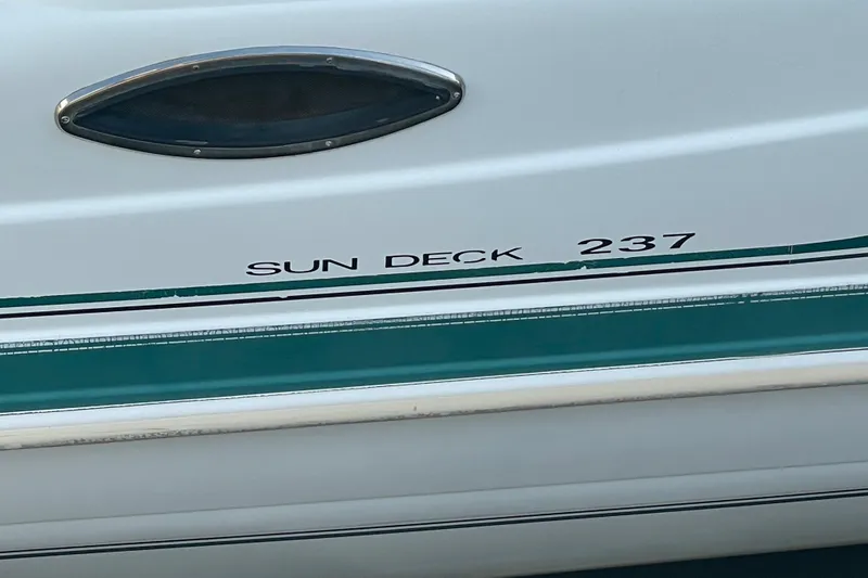Slide: The Image of 2000 Hurricane SunDeck 237 OB boat side view with model name visible. - 7