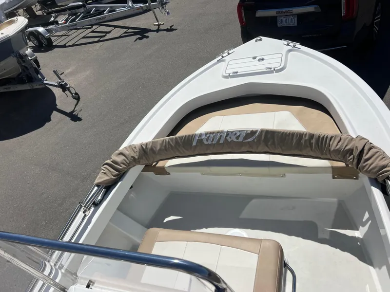 Slide: The Image of 2018 Parker 1801 Center Console boat, white with tan seating, parked on asphalt. - 5