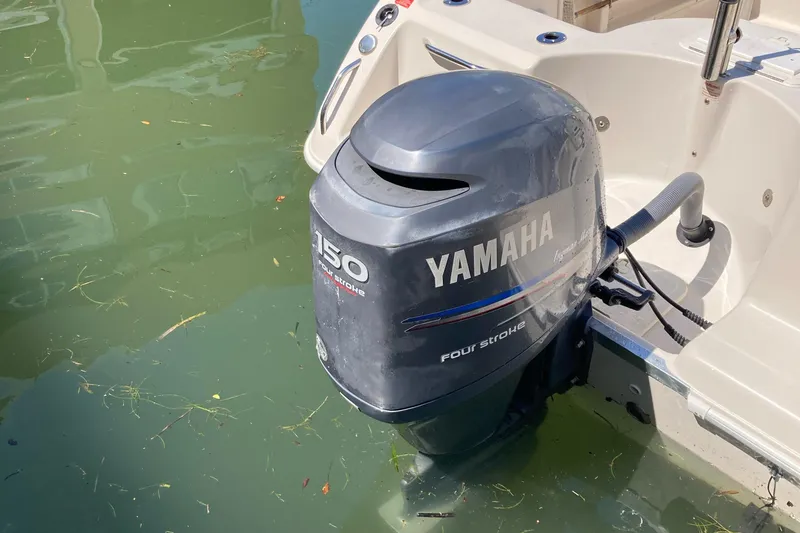 Slide: The Image of 2007 Cobia 215 Dual Console with Yamaha 150 outboard motor in water. - 10