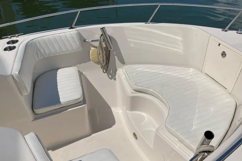 Slide: The Image of 2007 Cobia 215 Dual Console boat interior with white cushioned seating and stainless steel railings. - 2