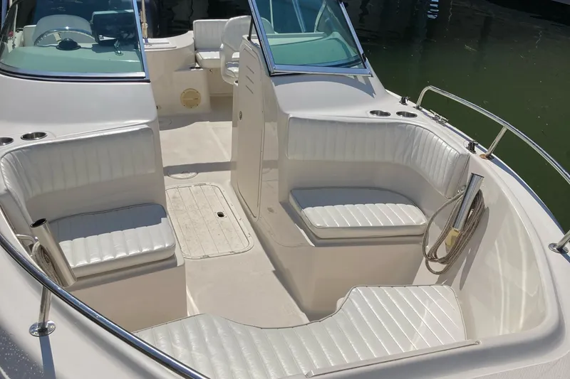 Slide: The Image of 2007 Cobia 215 Dual Console boat with white seating and open deck layout. - 4