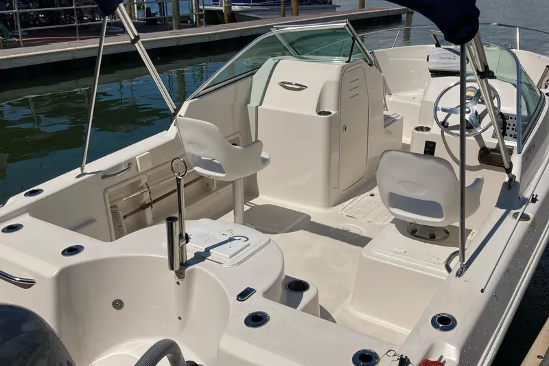 Slide: The Image of 2007 Cobia 215 Dual Console boat interior with seating and steering wheel at dock. - 5