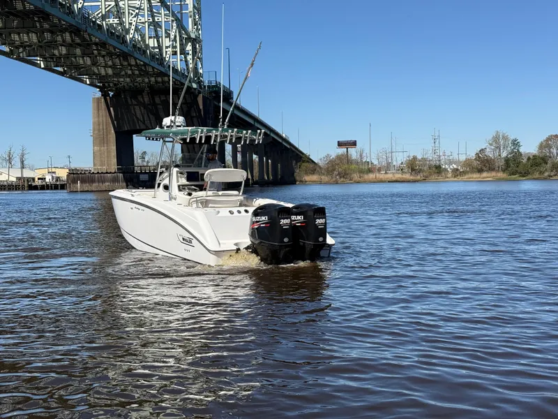 Slide: The Image of 2003 Boston Whaler 240 Outrage boat under a bridge on a sunny day. - 11