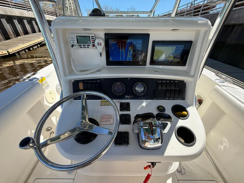 Slide: The Image of 2003 Boston Whaler 240 Outrage boat console with steering wheel, gauges, and navigation screens. - 15