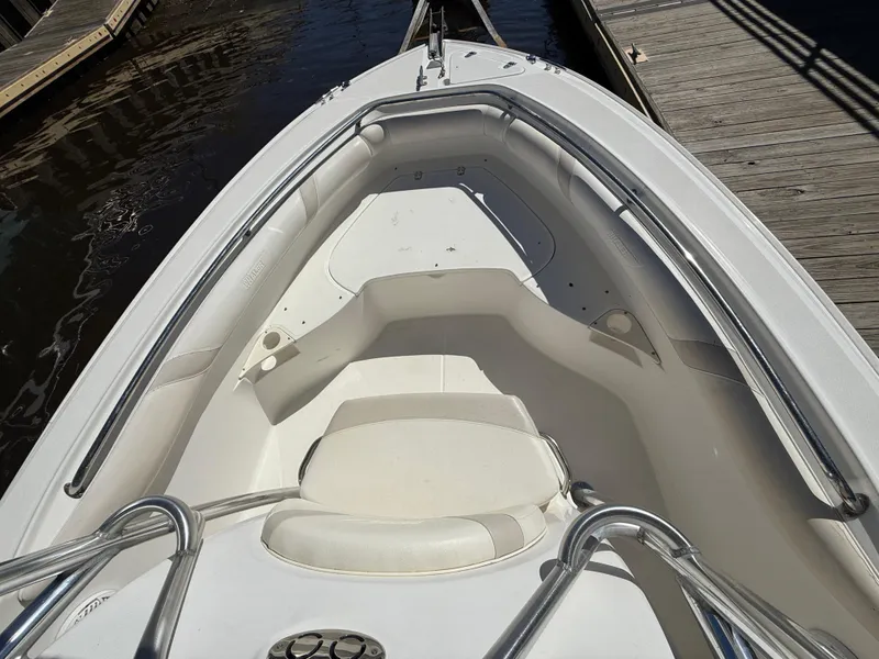Slide: The Image of 2003 Boston Whaler 240 Outrage boat interior with white seating and railings at dock. - 18