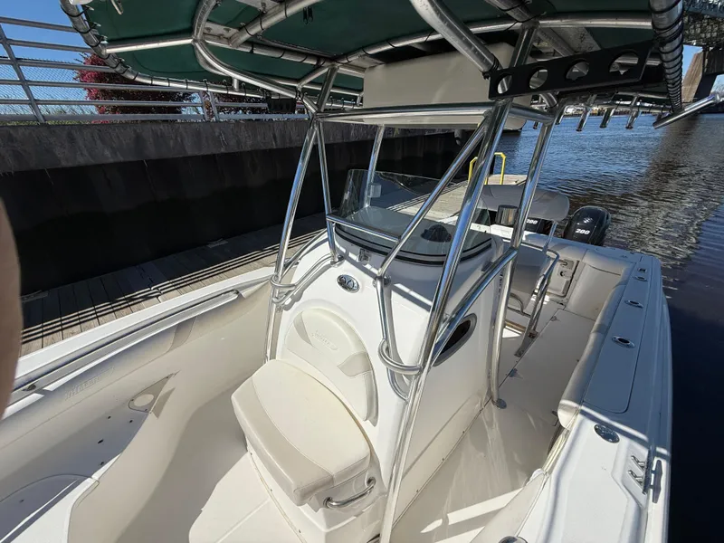 Slide: The Image of 2003 Boston Whaler 240 Outrage boat docked, featuring a center console and T-top. - 19