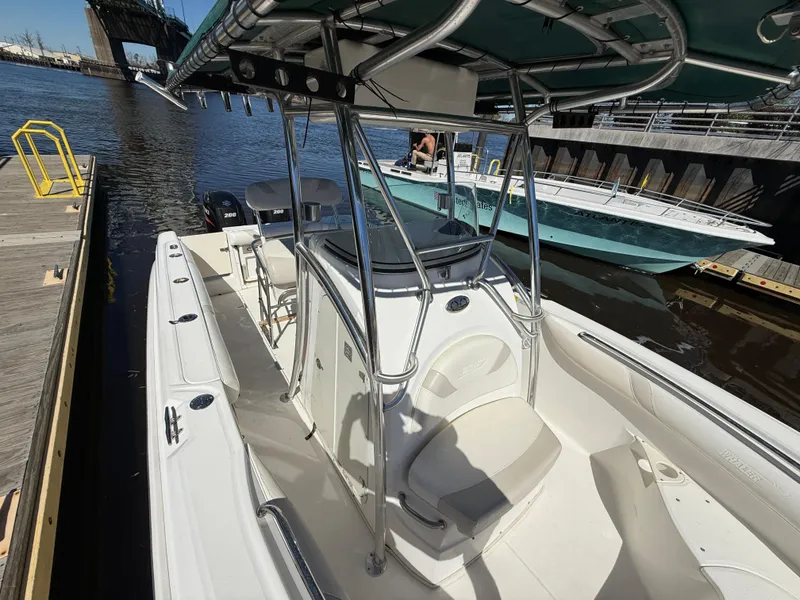 Slide: The Image of 2003 Boston Whaler 240 Outrage docked, featuring spacious deck and sturdy T-top. - 20