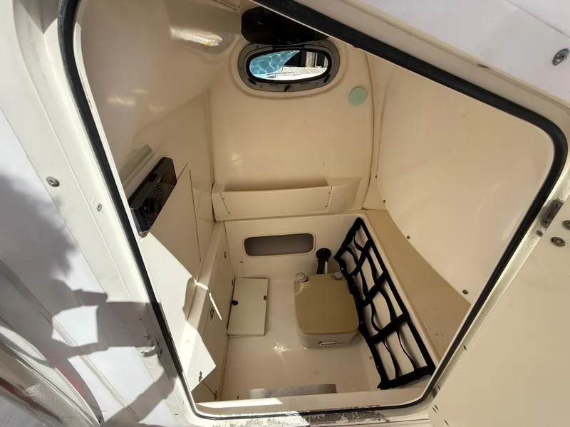 Slide: The Image of Interior cabin of 2003 Boston Whaler 240 Outrage boat, featuring storage and seating. - 23