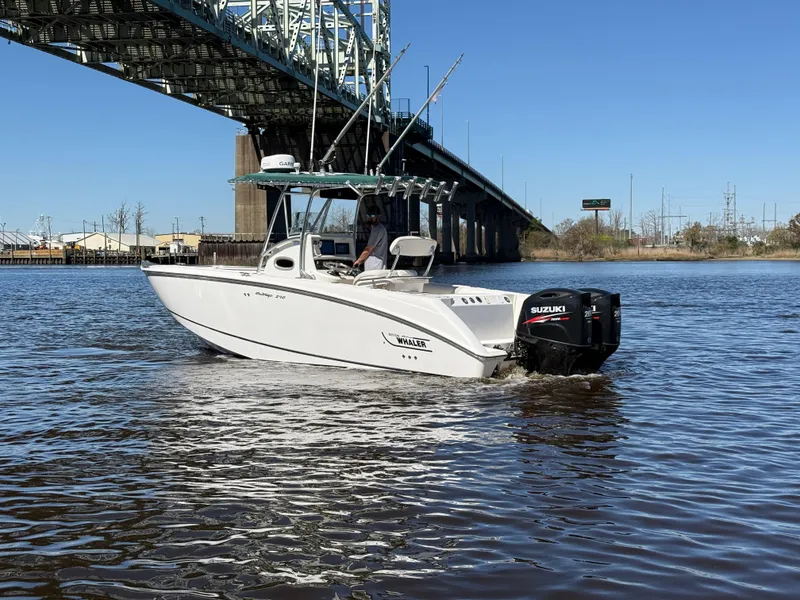 Slide: The Image of 2003 Boston Whaler 240 Outrage boat cruising under a bridge on a sunny day. - 3