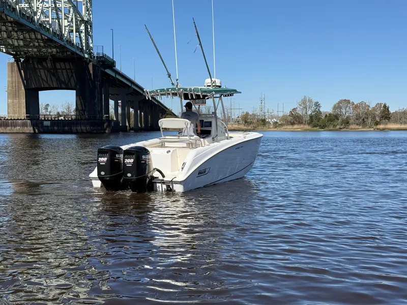 Slide: The Image of 2003 Boston Whaler 240 Outrage boat on water near a bridge, clear blue sky. - 8