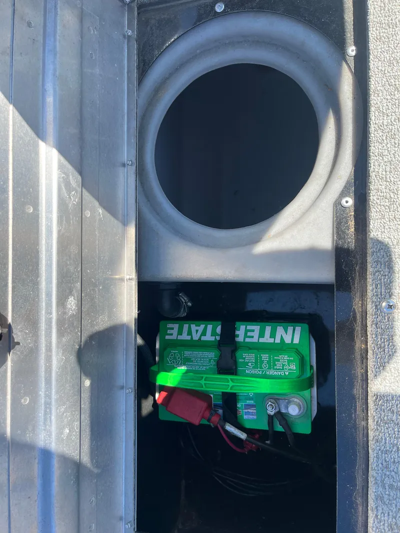 Slide: The Image of 2018 Tracker PRO GUIDE V165 WT boat battery compartment with green Interstate battery. - 13