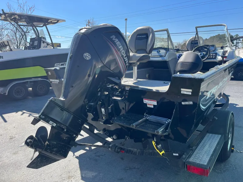 Slide: The Image of 2018 Tracker PRO GUIDE V165 WT boat with Mercury outboard motor, parked on a trailer. - 3