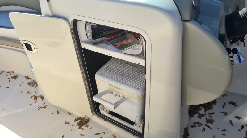 Slide: The Image of 2005 Sea Ray 200 Sundeck storage compartment with cooler and magazine. - 14