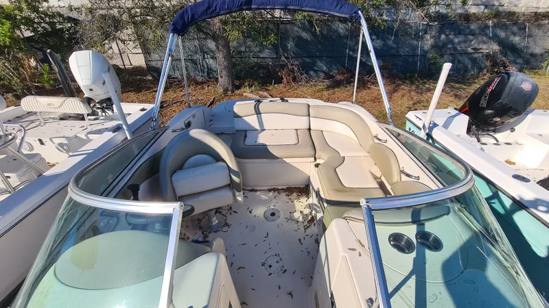 Slide: The Image of 2005 Sea Ray 200 Sundeck boat with spacious seating and canopy, docked outdoors. - 15