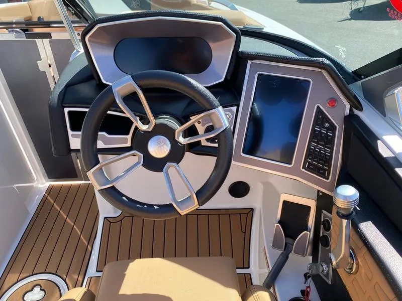 Slide: The Image of 2021 MasterCraft X24 boat dashboard with steering wheel and touchscreen controls. - 10
