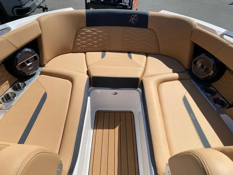 Slide: The Image of 2021 MasterCraft X24 boat interior with tan leather seating and wood flooring. - 13