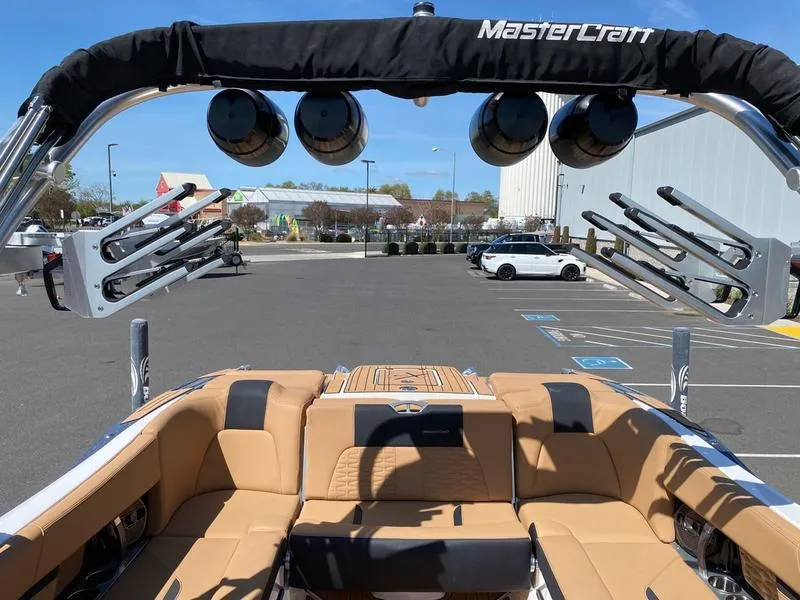 Slide: The Image of 2021 MasterCraft X24 boat interior with tan seating and wakeboard racks. - 16