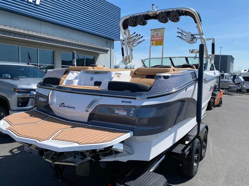 Slide: The Image of 2021 MasterCraft X24 boat on trailer, displayed outdoors near dealership. - 3