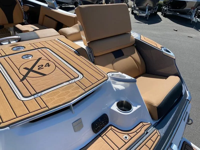 Slide: The Image of 2021 MasterCraft X24 boat interior with tan seating and wood accents. - 5