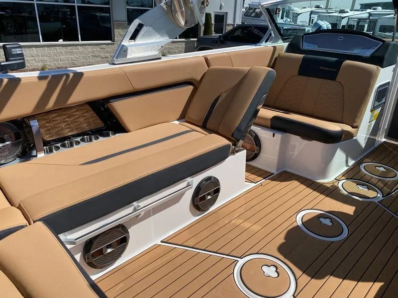 Slide: The Image of 2021 MasterCraft X24 boat interior with tan seating and wood-style flooring. - 8
