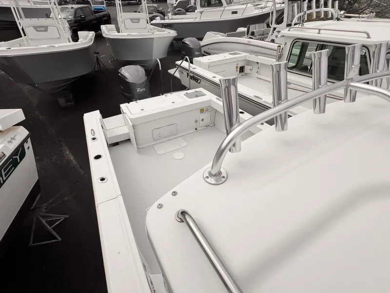 Slide: The Image of 2022 Parker 2320 SL boat deck with stainless steel railings and multiple boats in background. - 2