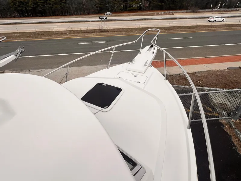 Slide: The Image of 2022 Parker 2320 SL boat bow view, parked near a road. - 3