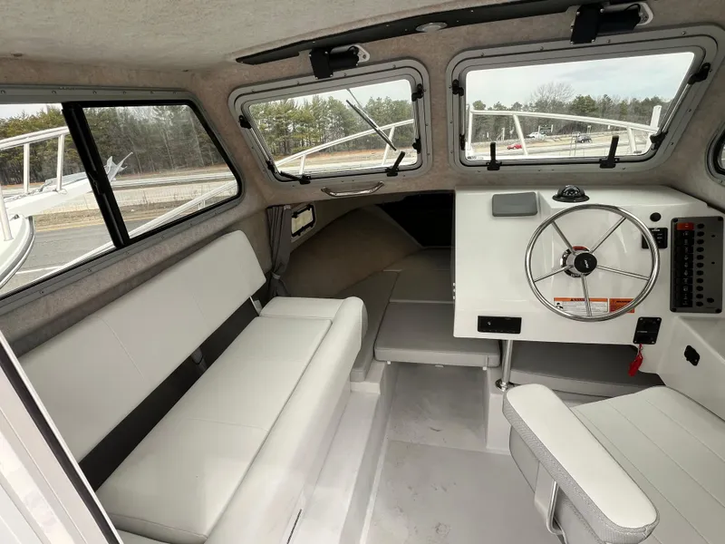Slide: The Image of Interior of a 2022 Parker 2320 SL boat, featuring seating and steering wheel. - 5