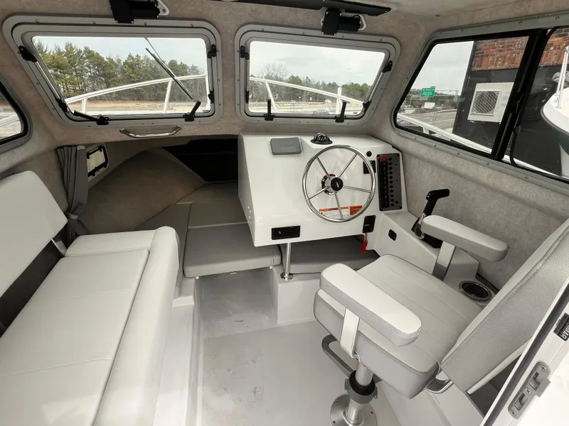 Slide: The Image of Interior of a 2022 Parker 2320 SL boat with white seating and steering wheel. - 6