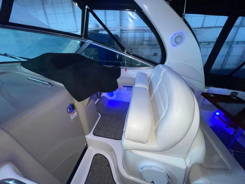Slide: The Image of Interior of 2005 Sea Ray 300 Sundancer boat with white seating and blue lighting. - 15