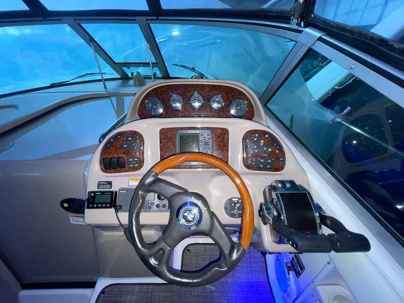 Slide: The Image of 2005 Sea Ray 300 Sundancer helm with wood accents and modern navigation controls. - 16