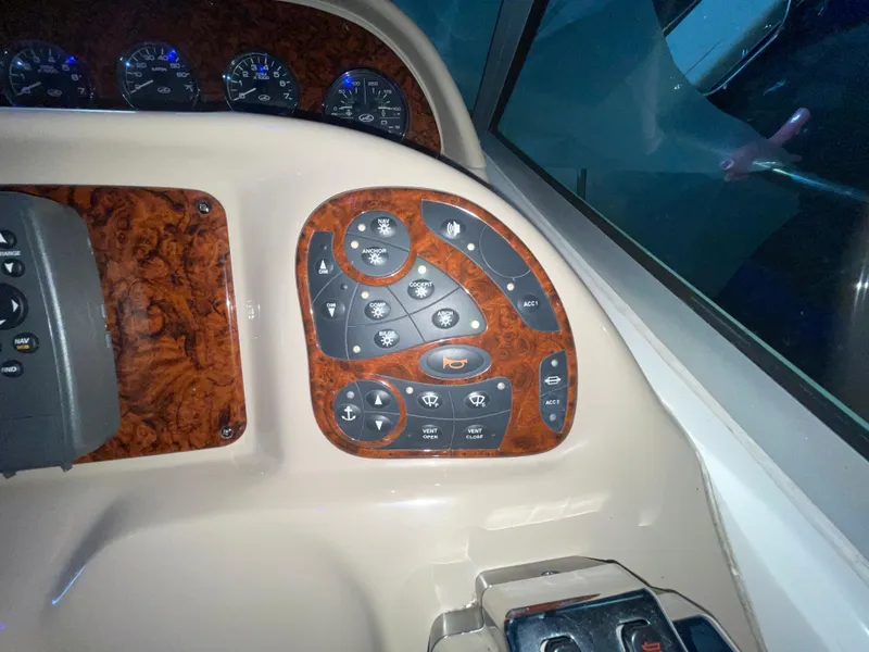 Slide: The Image of Dashboard controls of a 2005 Sea Ray 300 Sundancer boat with wood paneling. - 18