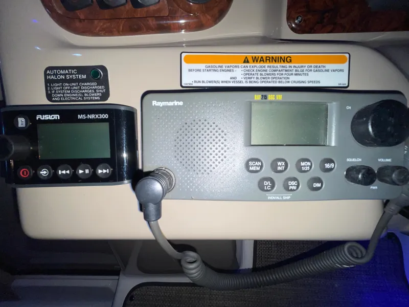 Slide: The Image of Control panel of a 2005 Sea Ray 300 Sundancer with radio and warning labels. - 23