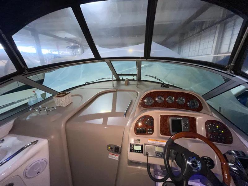 Slide: The Image of 2005 Sea Ray 300 Sundancer helm with wood accents and modern controls. - 24