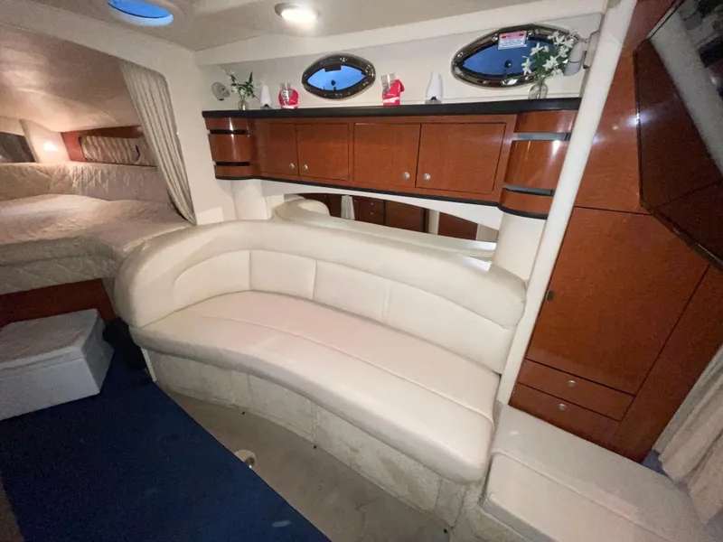 Slide: The Image of Interior of 2005 Sea Ray 300 Sundancer with cream leather seating and wooden cabinetry. - 26