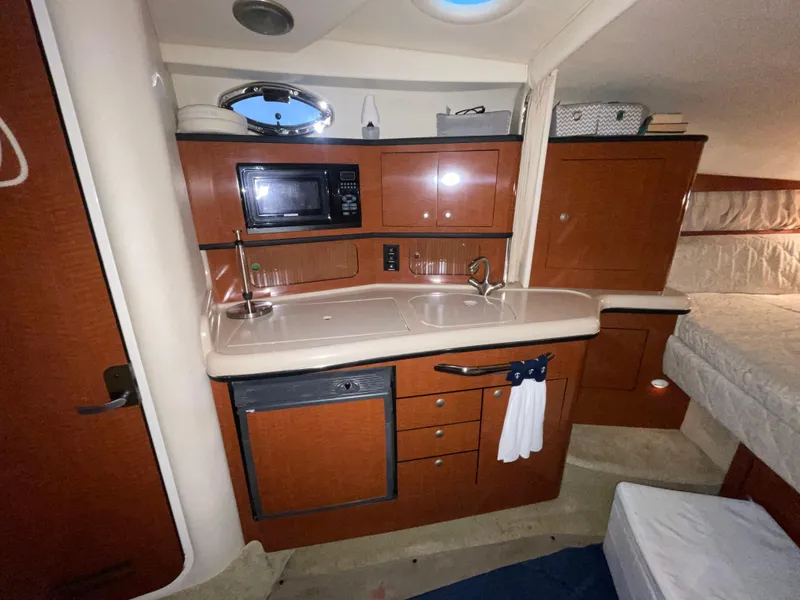 Slide: The Image of 2005 Sea Ray 300 Sundancer interior with kitchenette, microwave, and sink. - 27